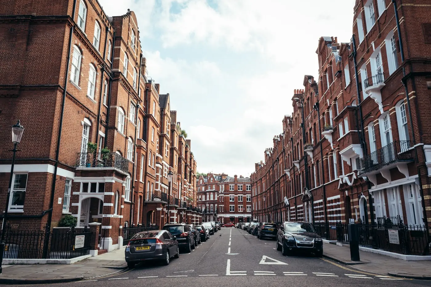A row of red-brick Victorian mansion blocks on a London street